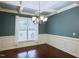 Formal dining room featuring elegant chandelier, decorative trim, and a large window providing ample natural light at 337 Shadowdale Ln, Rolesville, NC 27571