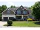 Attractive home featuring a well-manicured lawn, two-car garage, stone and siding accents, and mature trees at 337 Shadowdale Ln, Rolesville, NC 27571