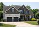Beautiful home showcasing a two-car garage, stone accents, lush lawn, and landscaped shrubs offering curb appeal at 337 Shadowdale Ln, Rolesville, NC 27571