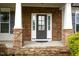Inviting front porch with brick pillars and dark front door at 337 Shadowdale Ln, Rolesville, NC 27571