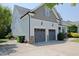 Two-car garage and side view of the home featuring lush landscaping and beautiful curb appeal on a sunny day at 337 Shadowdale Ln, Rolesville, NC 27571