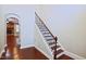 Hallway with wooden staircase, hardwood floors, and an arched doorway leading to the living room at 337 Shadowdale Ln, Rolesville, NC 27571