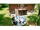 Brick house backyard with a fire pit circled by chairs, a deck, and lush greenery at 3750 Mebane Rogers Rd, Mebane, NC 27302
