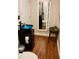 Modern bathroom features a unique blue glass vessel sink, hardwood floors, and a storage mirror cabinet at 3750 Mebane Rogers Rd, Mebane, NC 27302