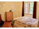 Cozy bedroom featuring a colorful quilt and a window with natural light at 3750 Mebane Rogers Rd, Mebane, NC 27302