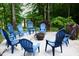 Outdoor entertaining: paved fire pit area with ample blue Adirondack seating for relaxing outside in a wooded back yard at 3750 Mebane Rogers Rd, Mebane, NC 27302