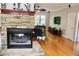 Living room with stone fireplace, hardwood floors, and ample natural light from the large window at 3750 Mebane Rogers Rd, Mebane, NC 27302