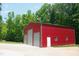 Outbuilding: Exterior view of a red metal outbuilding/shed with three garage doors on a concrete pad at 3750 Mebane Rogers Rd, Mebane, NC 27302