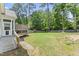 Backyard featuring a screen porch and ramp with a grassy area and border of trees at 3914 Old Chapel Hill Rd, Durham, NC 27707