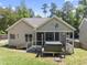 Back exterior featuring a screen porch and hot tub, with grassy areas at 3914 Old Chapel Hill Rd, Durham, NC 27707