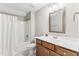Bright bathroom features a wooden vanity, a shower with white curtain, and tile floors at 3914 Old Chapel Hill Rd, Durham, NC 27707