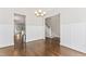 Open dining room featuring hardwood floors, decorative chandelier, and white wainscoting at 3914 Old Chapel Hill Rd, Durham, NC 27707