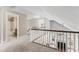 Hallway featuring white banisters, carpeted floors, and views of the downstairs fireplace at 3914 Old Chapel Hill Rd, Durham, NC 27707