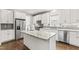 Modern white kitchen featuring a large island with granite countertops and stainless steel appliances at 3914 Old Chapel Hill Rd, Durham, NC 27707