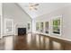 Open living room showcasing high ceilings, fireplace, ceiling fan, and access to outdoor space at 3914 Old Chapel Hill Rd, Durham, NC 27707