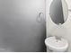 Stylish powder room with modern fixtures, a round mirror, and neutral gray walls at 3914 Old Chapel Hill Rd, Durham, NC 27707