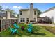 Cozy backyard with a fire pit and blue Adirondack chairs, ideal for outdoor gatherings and relaxation at 4216 Lake Woodard Dr, Raleigh, NC 27604