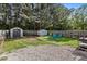 Spacious backyard with storage sheds, blue lawn chairs, and lush greenery at 4216 Lake Woodard Dr, Raleigh, NC 27604