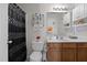Bright bathroom featuring a toilet, shower with black patterned curtain and brown vanity at 4216 Lake Woodard Dr, Raleigh, NC 27604