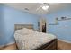 Comfortable bedroom with blue walls, ceiling fan, wood-look floors and an open closet at 4216 Lake Woodard Dr, Raleigh, NC 27604