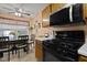 Cozy kitchen featuring wooden cabinets, black appliances, and a breakfast table with seating at 4216 Lake Woodard Dr, Raleigh, NC 27604