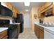 Well lit kitchen featuring tile floors, black appliances, wooden cabinets and white countertops at 4216 Lake Woodard Dr, Raleigh, NC 27604
