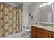 Bathroom featuring vanity with granite countertops, brown cabinets, a shower and tile flooring at 4306 Infinity Ln, Durham, NC 27705