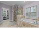Bathroom featuring a glass shower, a soaking tub under a window, and tile flooring at 4306 Infinity Ln, Durham, NC 27705