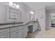 Bathroom featuring double sink vanity with granite countertops, gray cabinets, and tile flooring at 4306 Infinity Ln, Durham, NC 27705