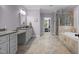 A large bathroom with double vanities, a soaking tub and a glass enclosed shower at 4306 Infinity Ln, Durham, NC 27705