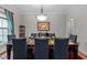 A dining room with a large table set for six with a red rug and a window with blue curtains at 4306 Infinity Ln, Durham, NC 27705