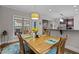 A dining room with a wooden table set for four and views to the deck and kitchen at 4306 Infinity Ln, Durham, NC 27705