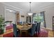 A dining room with a large table set for six with a red rug and a window with blue curtains at 4306 Infinity Ln, Durham, NC 27705