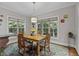 A dining room with a wooden table set for four and a view to the backyard through two large windows at 4306 Infinity Ln, Durham, NC 27705