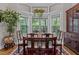 Elegant dining room with hardwood floors, large windows, and a formal dining set at 4306 Infinity Ln, Durham, NC 27705