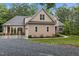 View of home with stone and siding, driveway, and landscaping at 4306 Infinity Ln, Durham, NC 27705