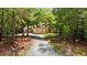 Long gravel driveway leading to a beautiful home surrounded by trees at 4306 Infinity Ln, Durham, NC 27705