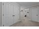 Neutral hallway featuring carpet, a double door closet, and an entrance to a bedroom at 4306 Infinity Ln, Durham, NC 27705