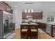 A kitchen with brown cabinets, stainless steel appliances, granite counters, an island and two counter stools at 4306 Infinity Ln, Durham, NC 27705