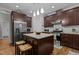 A kitchen with brown cabinets, stainless steel appliances, granite counters, an island and two counter stools at 4306 Infinity Ln, Durham, NC 27705