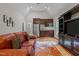 A living room features a sofa with an entertainment center with small kitchen to the back at 4306 Infinity Ln, Durham, NC 27705