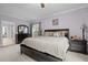 A well-lit main bedroom with a ceiling fan, king bed, large window, dresser and nightstands at 4306 Infinity Ln, Durham, NC 27705
