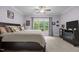 A well-lit main bedroom with a ceiling fan, king bed, large window, dresser and TV at 4306 Infinity Ln, Durham, NC 27705