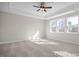 Spacious bedroom featuring plush carpeting, a ceiling fan, and natural light streaming through three large windows at 448 Golden Dragonfly St, Wake Forest, NC 27587