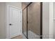 A modern tiled walk-in shower featuring a glass door at 448 Golden Dragonfly St, Wake Forest, NC 27587