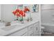 Bathroom features double sinks, white cabinets and quartz countertops, with decorative floral arrangement at 456 Golden Dragonfly St, Wake Forest, NC 27587