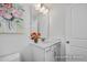 Bright bathroom with white cabinets, quartz countertop, single sink and decorative floral arrangement at 456 Golden Dragonfly St, Wake Forest, NC 27587