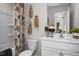 Bathroom with a white vanity, decorative wall hangings, and a shower with patterned curtains at 456 Golden Dragonfly St, Wake Forest, NC 27587