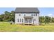 Two-story home with neutral siding and a covered porch nestled in a green landscape at 456 Golden Dragonfly St, Wake Forest, NC 27587