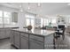 Bright, open kitchen features granite island with seating and pendant lights, next to dining and living area at 456 Golden Dragonfly St, Wake Forest, NC 27587